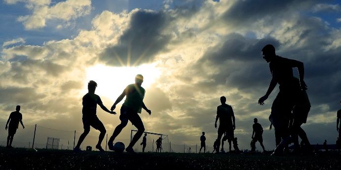 Fußballtraining bei wolkenbehangenem Himmel und Sonnenschein.