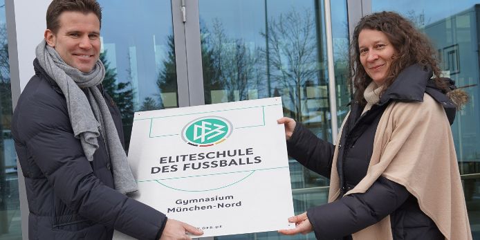 Das Gymnasium München-Nord hat das Prädikat „Eliteschule des Fußballs“ erhalten. Felix Brych übergibt die Plakette an Schulleiterin Dr. Petra Reinold.